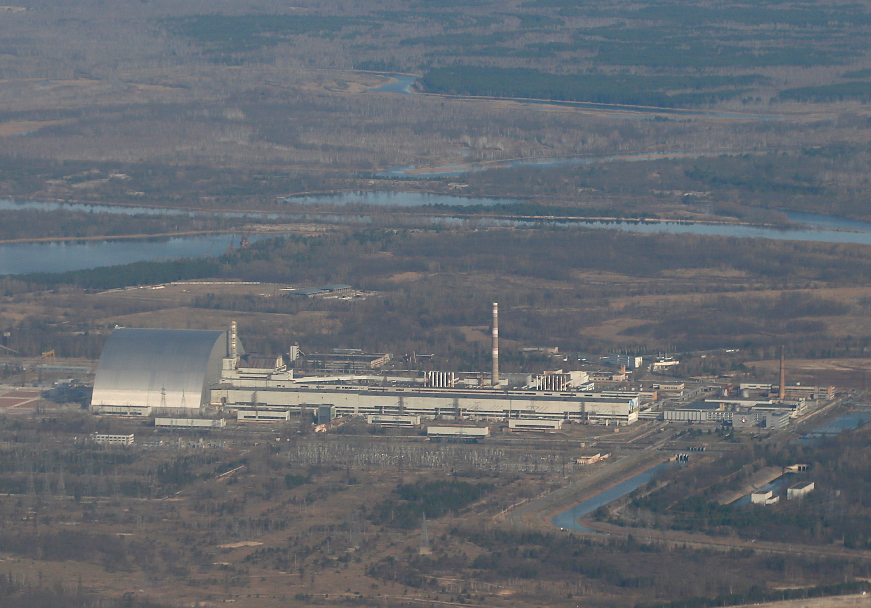Una vista aérea desde un avión muestra una nueva estructura de confinamiento seguro (NSC) sobre el antiguo sarcófago que cubre el cuarto reactor dañado en la planta de energía nuclear de Chernobyl durante un recorrido por la zona de exclusión de Chernobyl, Ucrania, el 3 de abril de 2021. REUTERS/Gleb Garanich /Foto de archivo