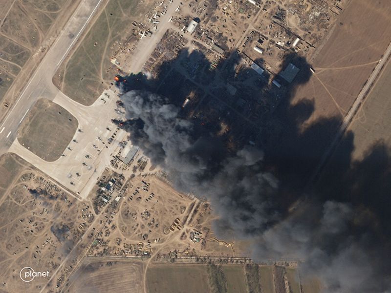 Una imagen satelital muestra una columna de humo que se eleva desde el Aeropuerto Internacional de Kherson el martes 15 de marzo.  Cuando se amplía, las imágenes muestran varios helicópteros en llamas.