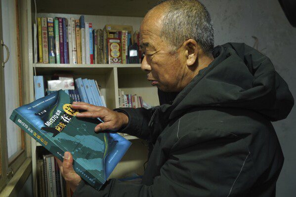 El granjero chino Li Eryu mira un libro escrito sobre el vuelo MH370 desaparecido de Malaysia Airlines desde la estantería de la antigua habitación de su hijo en una aldea en Handan, provincia de Hebei, en el norte de China, el 28 de febrero de 2024. Li, cuyo hijo estaba en el avión, continúa para buscar respuestas después de... Década.  La desconcertante desaparición del vuelo MH370 sigue cautivando a personas de todo el mundo.  El Boeing 777 partió de Kuala Lumpur con 239 personas a bordo el 8 de marzo de 2014, pero desapareció del radar poco después y nunca llegó a su destino, Beijing.  Los investigadores dicen que alguien apagó intencionalmente el sistema de comunicaciones del avión y lo desvió de su rumbo.  (Foto AP/Emily Wang Fujiyama)