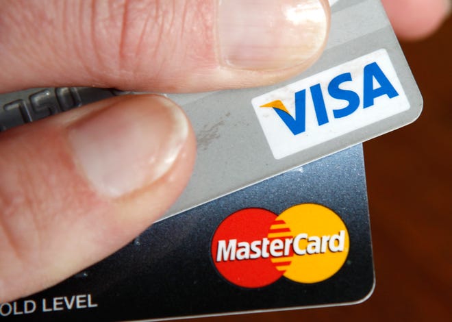 Un usuario de tarjeta de crédito muestra sus tarjetas en Washington el 22 de febrero de 2010.