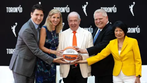 Getty Images El primer ministro Justin Trudeau, la comisionada de la WNBA, Cathy Engelbert, el presidente de la MLSE, Larry Tannenbaum, el primer ministro de Ontario, Doug Ford, y la alcaldesa de Toronto, Olivia Chow.  El primer ministro Justin Trudeau y otras figuras destacadas anunciaron la expansión de la WNBA a Canadá con un equipo en Toronto.