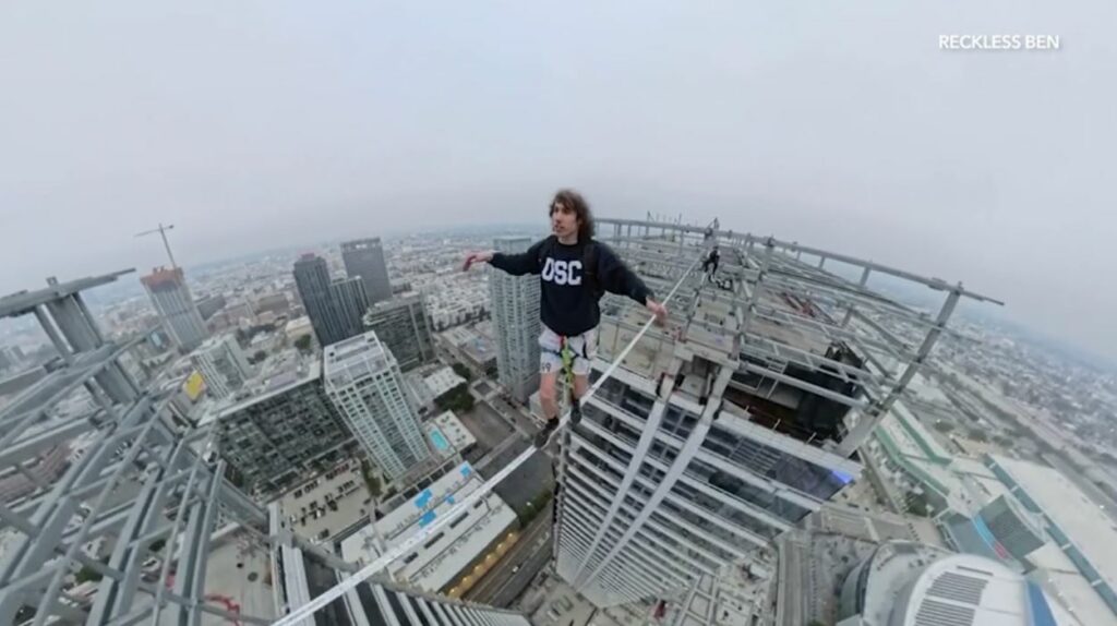 Daredevil camina sobre una cuerda entre los rascacielos del centro de Los Ángeles, muy por encima del horizonte.