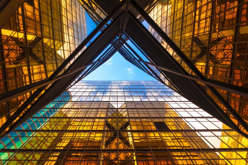 Una vista en ángulo bajo de los edificios de oficinas de Hong Kong desde abajo, con el cielo visible a través de una cruz en forma de X.