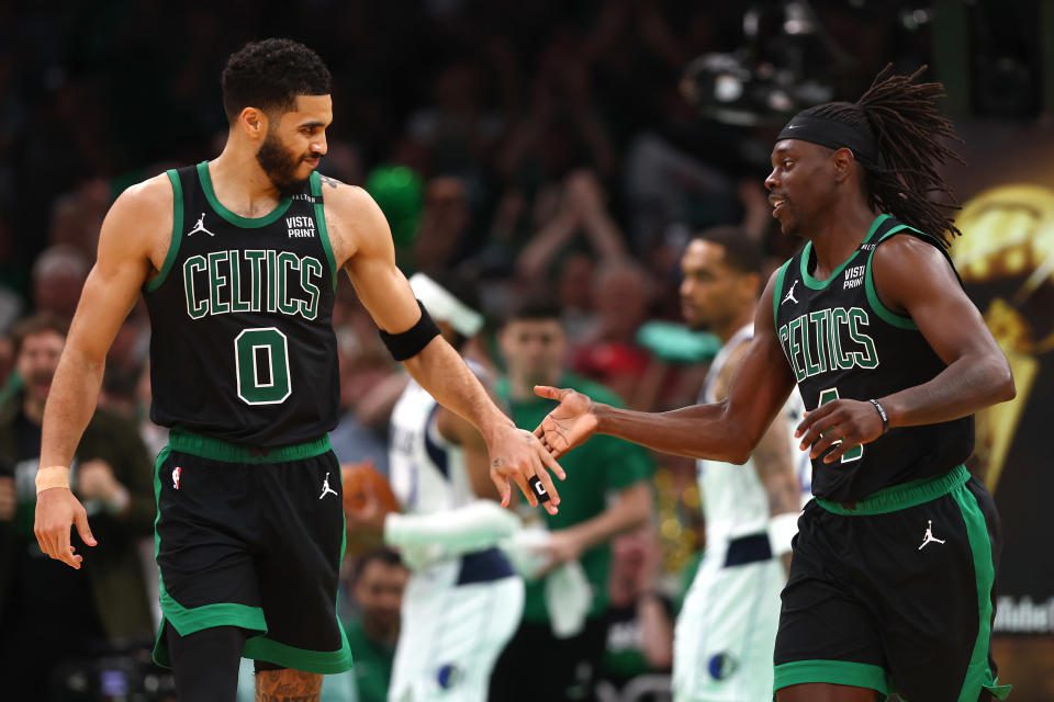 Jayson Tatum, izquierda, cede el control de la ofensiva de los Celtics a Jrue Holiday en la victoria de los Celtics en el Juego 2 el domingo.  (Maddie Meyer/Getty Images)