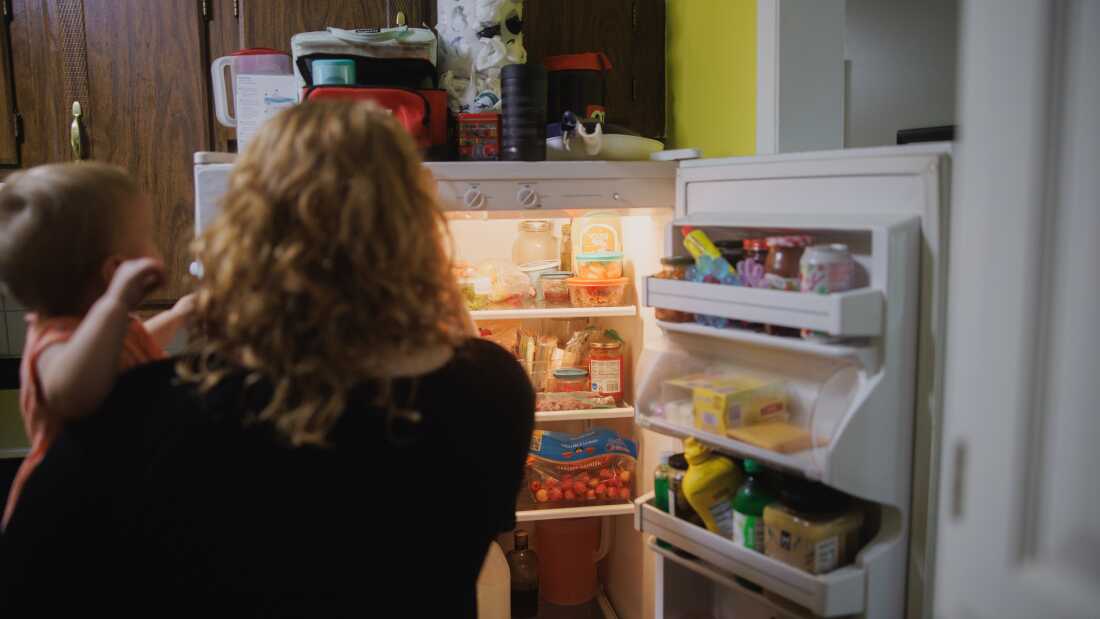 Annalise y Ellie Corrence se paran frente al refrigerador mientras eligen la cena en su casa en Belton, Missouri, el 17 de julio.