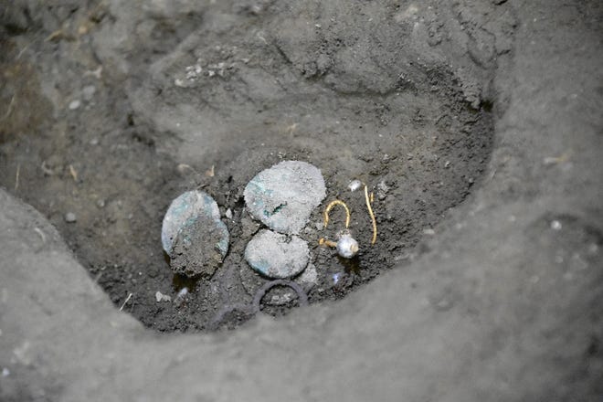 Monedas romanas antiguas y un arete en el sitio arqueológico de la antigua ciudad de Pompeya, en Pompeya, Italia, 5 de julio de 2024.