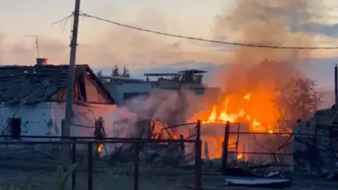     IZ.RU/Reuters Una casa en llamas en la ciudad de Sudza, región de Kursk, en el oeste de Rusia. Foto: 7 de agosto de 2024